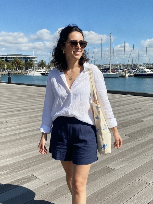 Wynyard Quarter waterfront boardwalk in navy linen shorts and white shirt
